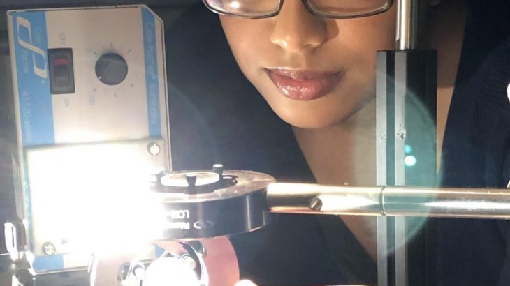 McMaster University graduate student Fariha Mahmood uses new computing technology by shining patterned bands of light through a polymer cube. (Credit: McMaster University)