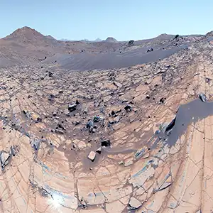 360-degree panorama of an area nicknamed "Falbreen" on May 26, 2025, the 1,516th Martian day, or sol, of the mission. Ninety-six separate images were stitched together to make the panorama. This enhanced-color version, which had its color bands processed to improve visual contrast and accentuate color differences, shows the Martian sky to be remarkably clear and deceptively blue. Credit: NASA/JPL
