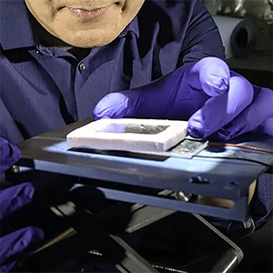 Black metal boost. Rochester researcher Chunlei Guo tests a solar thermoelectric generator (STEG) etched with femtosecond laser pulses to boost solar energy absorption and efficiency. His lab’s innovative black metal technology design helps create a STEG device 15 times more efficient than previous devices, paving the way for new renewable energy technologies. Credit: University of Rochester