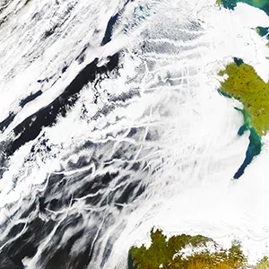 The streaks in this satellite image are from ships, which emit sulfate aerosols that can be toxic to humans and the environment. Aerosols also make the clouds more reflective. Efforts to curb pollution have reduced the amount of sunlight Earth reflects and accelerated warming, a new University of Washington study shows. Credit: NASA